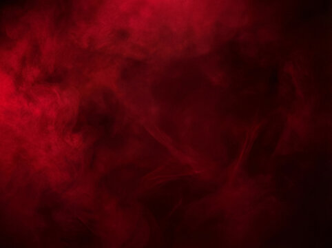 Intense deep red smoke swirling against a stark black background, creating an abstract and moody texture.