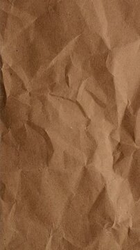 Stop-Motion Crumpled Kraft Paper Texture. Stop-motion animation quick successive changes of wrinkled brown kraft paper osurfaces, creating dynamic textured transitions with visible creases.
