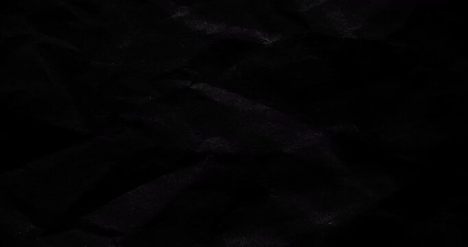Stop-Motion Crumpled Black Paper Texture. Stop-motion animation quick successive changes of wrinkled black kraft paper osurfaces, creating dynamic textured transitions with visible creases.