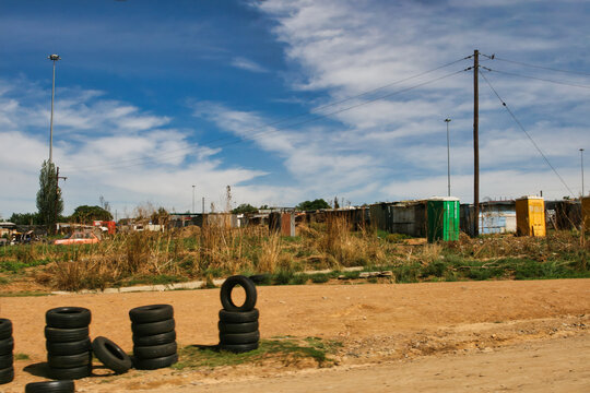 Informal Settlement with Portable Toilets and Tires in South Africa along a dirt roadside