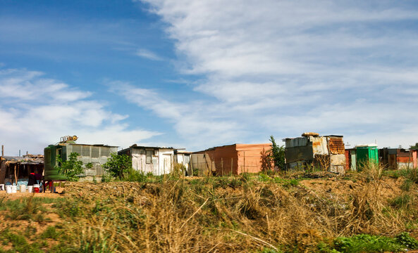 Informal Settlement with Portable Toilets and Tires in South Africa along a dirt roadside