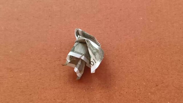 Single crumpled five hundred indian rupee currency bank note with wrinkles isolated on brown background. Stop motion extreme closeup top view. India deflation, rising GDP and economy recovery concept.