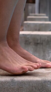 Woman placing bare foot onto wet step, shifting weight and showing footcare with animated droplets