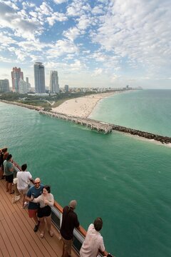 Miami, United States - 16 March 2026: View of vibrant turquoise waters contrasting with the bustling white sands of South Beach and a towering cityscape under a dynamic sky.