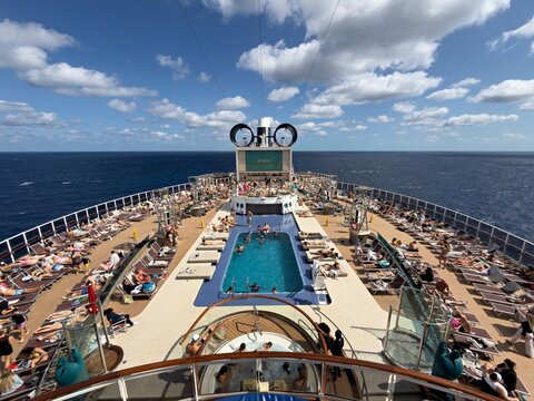 Nassau, The Bahamas - 19 March 2026: View of a vibrant cruise ship deck, where sun-kissed travelers relax by a glistening pool under a vast blue sky.