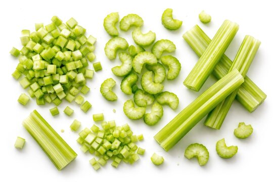 Close up of freshly chopped celery pieces in assorted forms on a pure white background from top view
