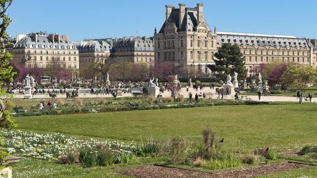 Visitors relax amid vibrant flowers and artistic statues