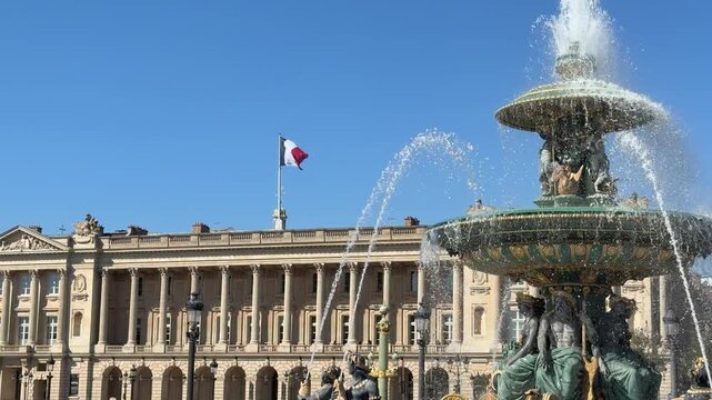 Detailed image of fountain with flag backdrop and water droplets