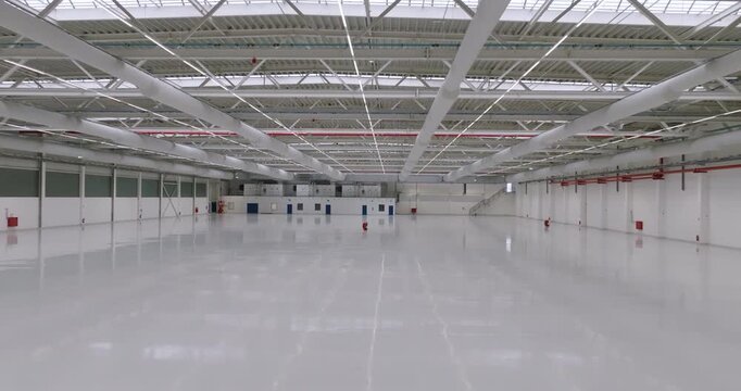 Interior view of an empty warehouse under construction with exposed ductwork and pillars