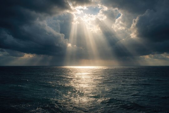 Daylight shining across ocean surface amid thick clouds