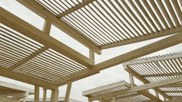 Parallel white wooden slats create a modern canopy against the soft sand. The clean lines evoke a sense of order and calm. This architectural detail feels refreshing and very peaceful.