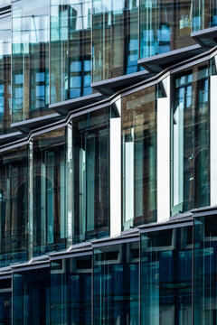 Modern architecture facade of glass windows captures office corporate finance pattern and symmetry with layered reflections and sleek urban innovation