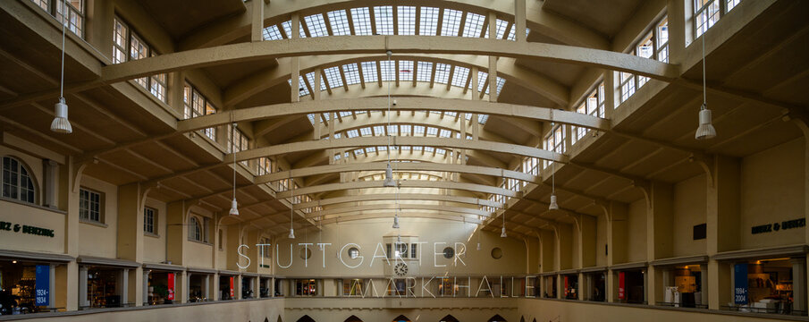 Iconic interior architecture of Stuttgarter Markthalle, featuring its distinctive vaulted ceiling with numerous skylights and exposed wooden beams, creating a bright, spacious atmosphere. Vintage pend