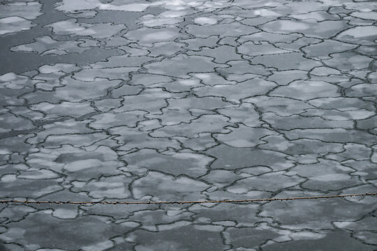 View of a mosaic of fractured ice floes create a mesmerizing pattern on the water's surface, a stark reminder of winter's icy grip, Tallinn, Estonia.