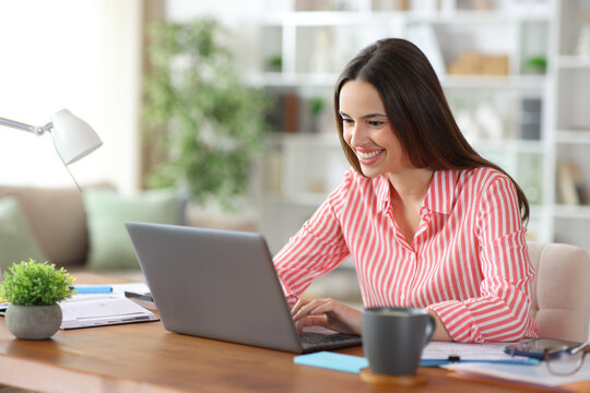 Happy tele worker working using laptop at home