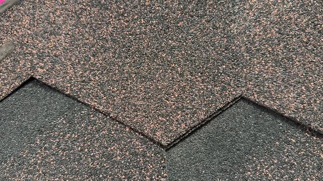 Hexagon pale red roof tiles close-up showing flexible asphalt shingles with granular texture, overlapping layout on cottage roof