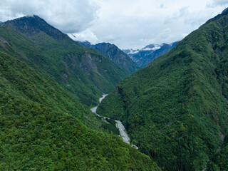 Fototapeta premium Aerial view of beautiful high altitude snow capped mountain and forest landscape