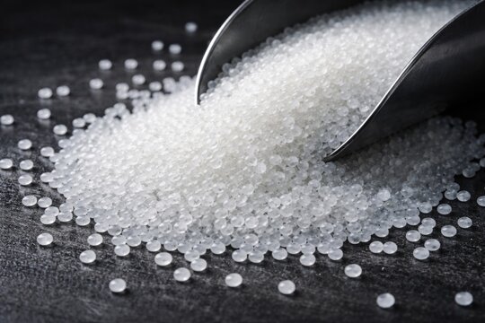High resolution image of polypropylene resin granules utilized in plastics industry production on dark setting