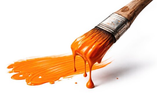 Brush with bold orange paint dripping on white background illustrating creative artistry