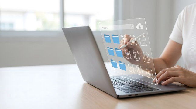 Woman using stylus pen with virtual document management system and folders hologram on laptop, Cloud storage and paperless office concept with digital file organization interface.