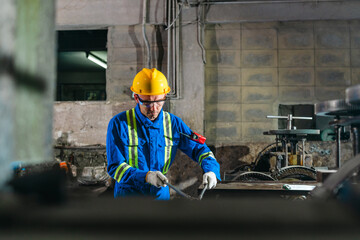 Fototapeta premium Factory Technicians Performing Heavy Machine Maintenance in Traditional Metal Workshop