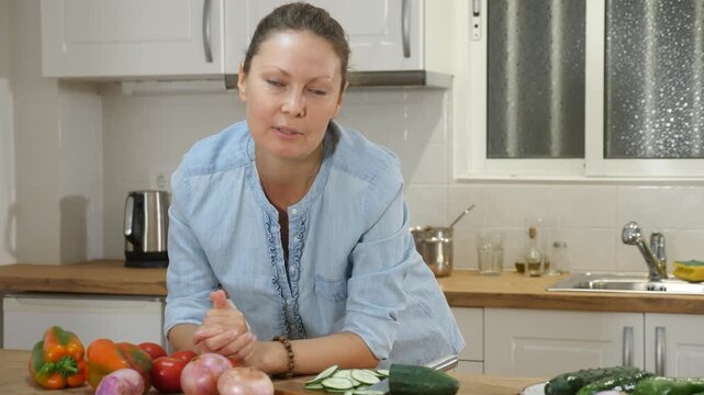Adult happy Caucasian woman about to cook in the kitchen home