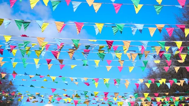 Festive flags against a blue sky. The flags at the fair flutter in the wind.
