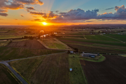Aerial view of sunset over farmland at Morpeth in New South Wales, Australia. Scenic rural landscape showing warm evening light across agricultural fields and countryside.
