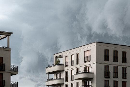 Residential apartments architecture facade in Frankfurt near Europagarten Germany showing urban storm clouds and storm light around a modern building exterior