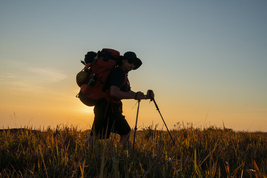 Adventure hiking at sunset nature trail outdoor activity warm environment side view reflection of exploration