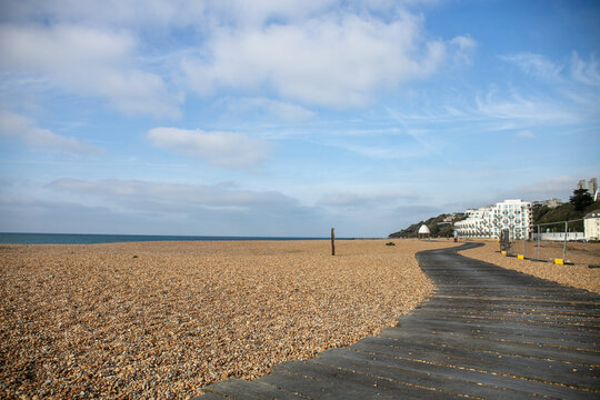 View of the Folkestone seafront in Kent, England, featuring coastal scenery and the modern Shoreline housing development as part of the town&rsquo;s waterfront regeneration. The sandy foreground highlights 