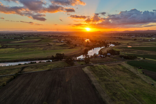 Aerial view of colourful sunset over Morpeth River and surrounding farmland in New South Wales, Australia. 