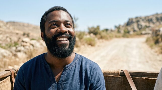African man smiling as Ethiopian eunuch traveling on desert road. Biblical scene from Acts 8 depicting official of Candace queen of Ethiopia listening to gospel teaching after Jerusalem.