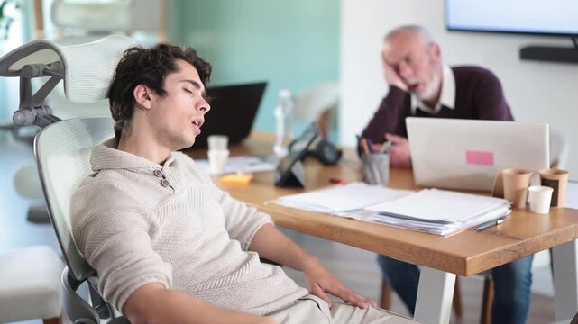 Tired men sleeps next to computer at work. Exhausting work schedule, overwork, overwork. Afternoon siesta at workplace. 