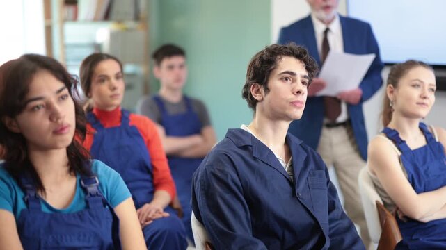 Group of young workers students sit on comfortable chairs in the classroom and watch a presentation and listen to a lecture in front of a qualified teacher