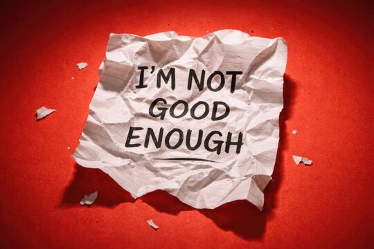 Crumpled note with self doubt phrase displayed on bright red backdrop