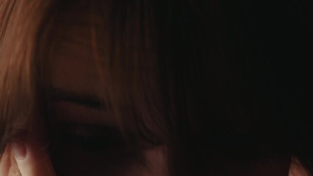 A close up of a tired and upset woman rubbing her face and eyes. She covers her face with her hands as she tries to relax and cope with stress. High quality 4k footage
