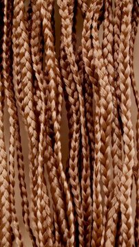 Closeup texture of Beautiful Long Smooth Flowing Brown Hair Braided into Pigtails Blowing in the Wind in Slow Motion. Natural hair care concept and barbershop or hairdressing. Healthy Shiny Hairs. 4k