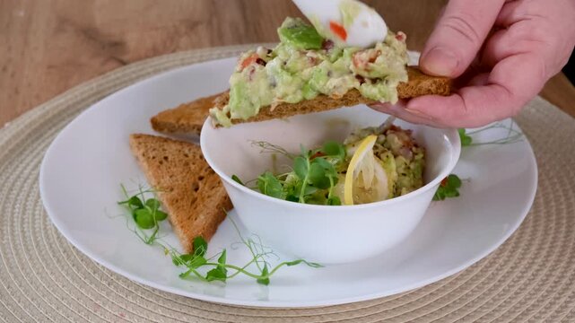 Healthy Breakfast Preparation Spreading Avocado on Bread