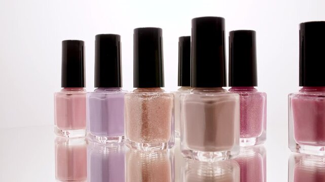 Colorful bottles of gel nail polishes. Manicure cover, uv gel, enamel, varnish with brush. Beauty salon, nail care product. Manicure concept. High quality 4k footage