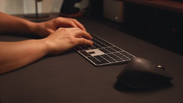 Close up of hands typing on a wireless computer keyboard