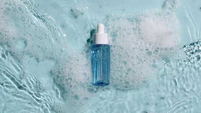 Bottle with a pipette for collagen serum, oil, toner on water texture background surface with bubbles of white soapy foam. Medical skin care. Packaging for design, advertising of a cosmetic product.4k