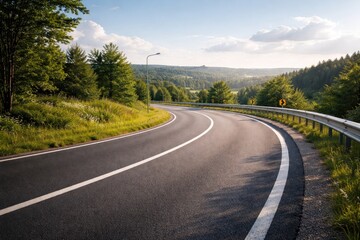 Fototapeta premium Open view of a clear bend along a refined pavement road with a crash barrier visible in the background