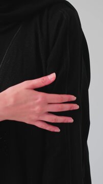 Hands of a young beautiful woman in a black national Arab dress abaya close-up.