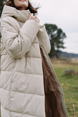 Coat, outdoor scene with a person wearing a warm puffer jacket in a chilly countryside, showcasing fashion, comfort and practical outerwear. © SHOTPRIME STUDIO
