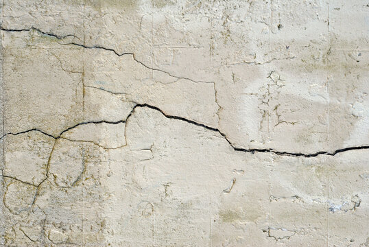 Old Plaster Wall with Cracks and Fissures in Close Up 