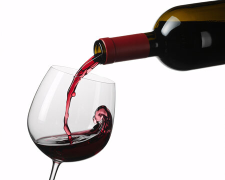 A bottle of red wine is being poured into a glass