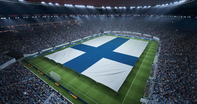 Professional Stadium Soccer Game Championship With Flag of Finland Spread Across the Pitch Before Football Match Start. Cheering Crowds of Fans Surround the Field. Aerial Elevated Static Wide Shot.