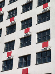 Fototapeta premium White high-rise apartment building with red air conditioner mounts