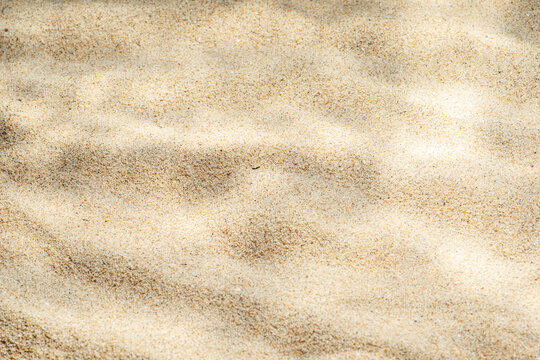 Sea sand texture with ripple patterns resembling underwater surface, ideal as abstract summer background.